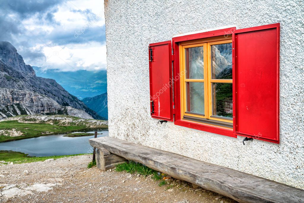 Red wooden window with mountain lake view