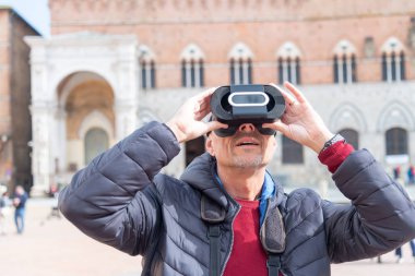 Vr gözlüklerini kullanarak ortaçağ kasabasını keşfeden mutlu adam. Teknikoloji ve turizm konsepti.