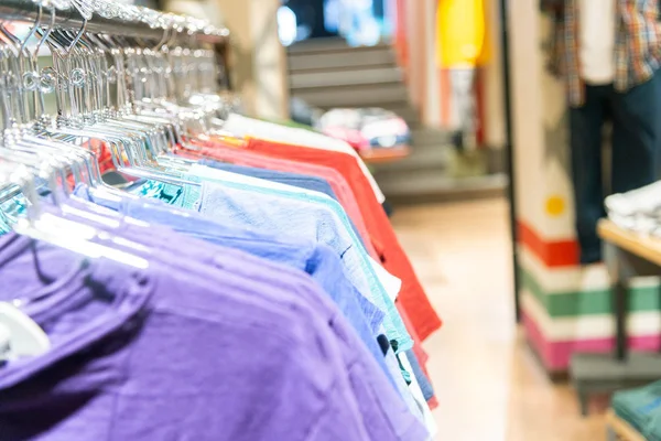 Camisetas coloridas alineadas en una tienda de ropa —  Fotos de Stock
