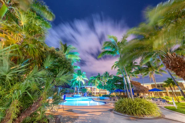 Noite estrelada com nuvens sobre uma bela piscina cercada por amigo — Fotografia de Stock