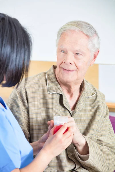 Enfermeira asiática dando pílulas para idosos no hospital — Fotografia de Stock