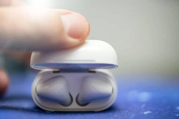 Modern wireless earphones held by man's hand — Stock Photo, Image