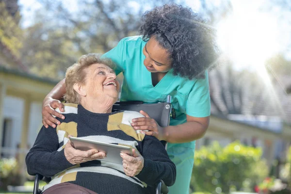 Afrikanische Ärztin Spielt Und Lächelt Mit Älteren Frauen Rollstuhl Garten — Stockfoto