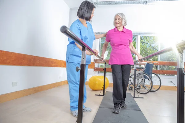 Ασιατική Ιατρική Βοηθός Βοηθά Ώριμη Ηλικιωμένη Γυναίκα Ασκήσεις Γυμναστικής Στα — Φωτογραφία Αρχείου