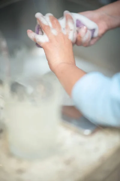 Chica joven lavando vasos en casa. Concepto de vida familiar — Foto de Stock