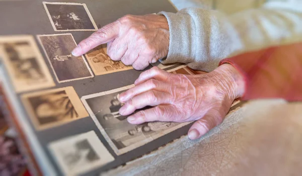 Elderly couple hands looking at old pictures album at home. Deta — Stock Photo, Image