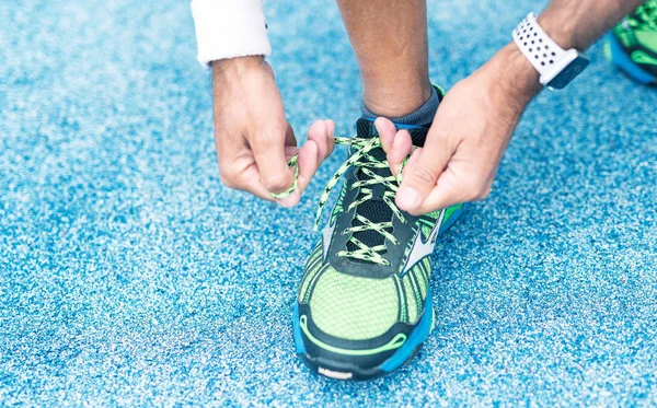Man tying running shoes lace in the park outdoor — Stock Photo, Image