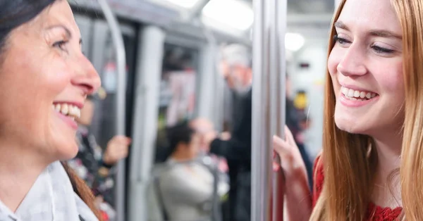Pár női meg szívesen beszélek metróállomástól vonaton — Stock Fotó