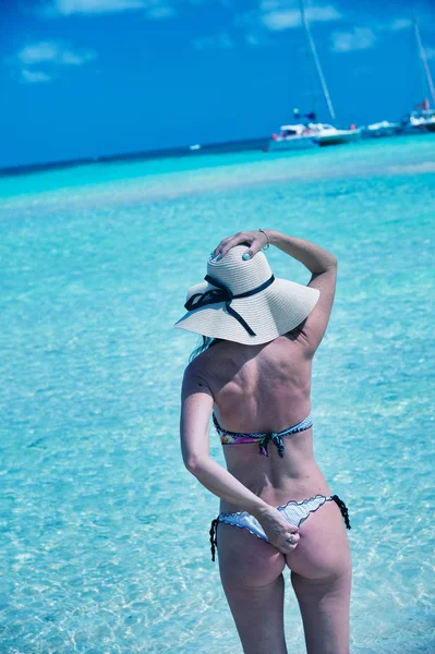 Mujer usando sombrero de paja en la frontera del océano tocando su cabeza y ba —  Fotos de Stock