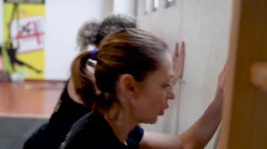 Orta yaşlı insanların spor salonunda birlikte çalıştığı görüntüler.