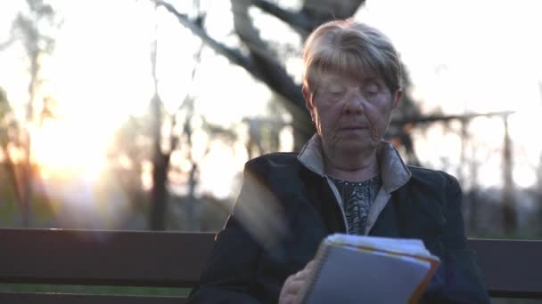 Nagranie Dojrzałej Kobiety Czytającej Książkę Ławce Parku — Wideo stockowe