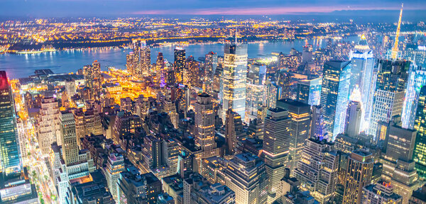 Tall skyscrapers of Midtown Manhattan, night aerial view.