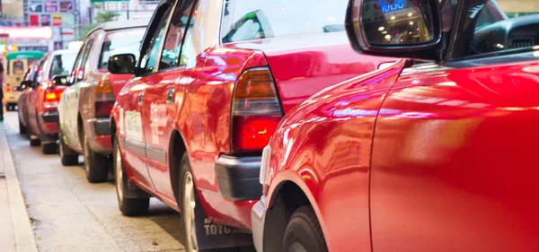 HONG KONG, CINA - MAGGIO 2014: Taxi cittadini e traffico al tramonto. H — Foto Stock