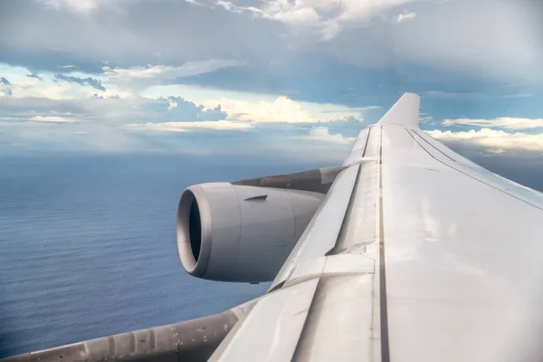 Křídlo letadla viděn z vnitřku okna letadla — Stock fotografie