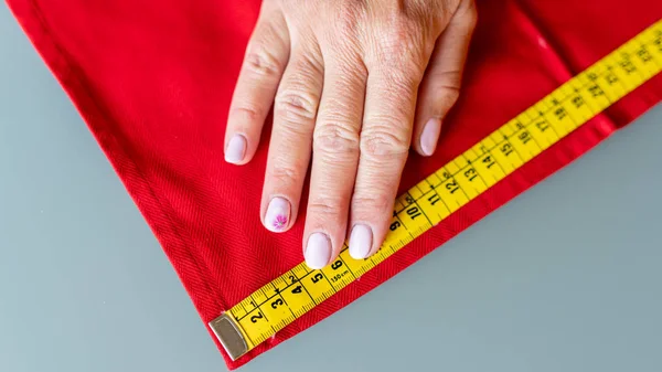 Vrouw het meten van een stof met de hand met de meter — Stockfoto