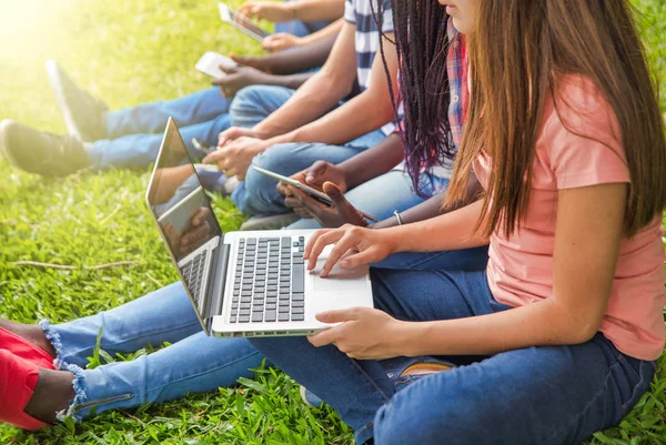 Dışarıda dizüstü bilgisayar kullanan bir grup genç..