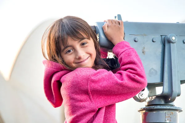 Ευτυχισμένο χαμογελαστή νεαρή κοπέλα επισκέπτονται την πόλη κρατώντας ένα τηλεσκόπιο — Φωτογραφία Αρχείου