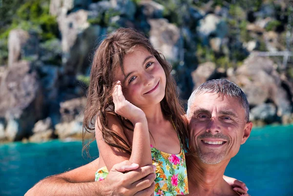 Glad man med dotter avkopplande på en vacker strand — Stockfoto