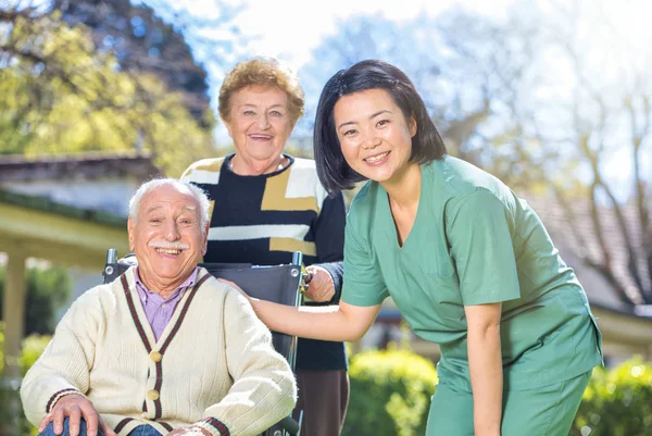 Oudere Echtparen Tuin Met Hun Verzorger — Stockfoto