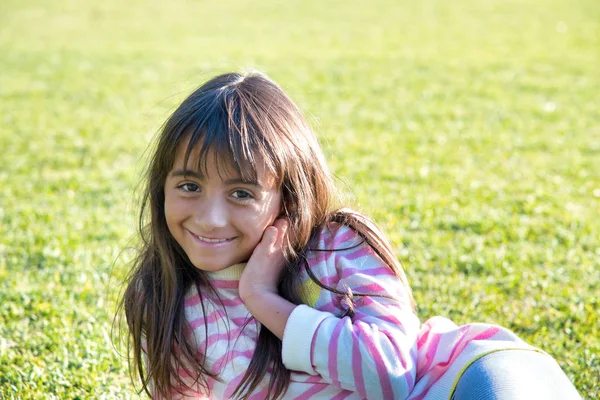 Young girl happy smiling lying on a park grass — Stock Photo, Image