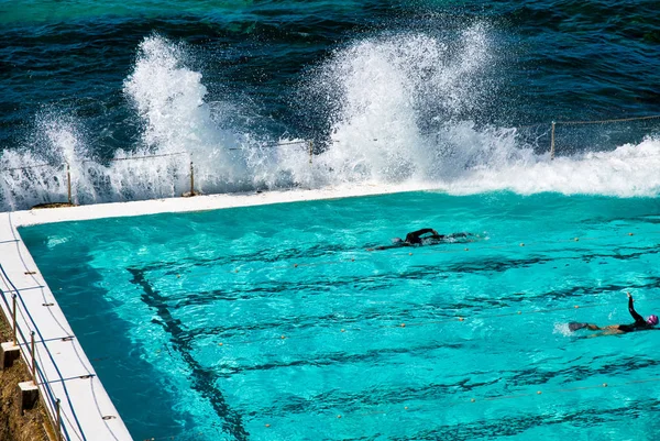 Nadadores desfrutando de bela piscina na fronteira oceânica — Fotografia de Stock