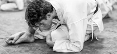 Genç adam ders sırasında karate çalışıyor.,