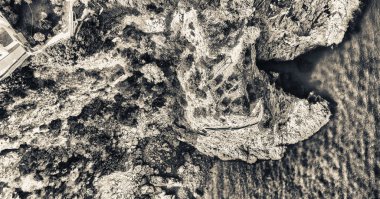 Kayaların okyanus üzerinden aşağı doğru yükü görüntülemek.