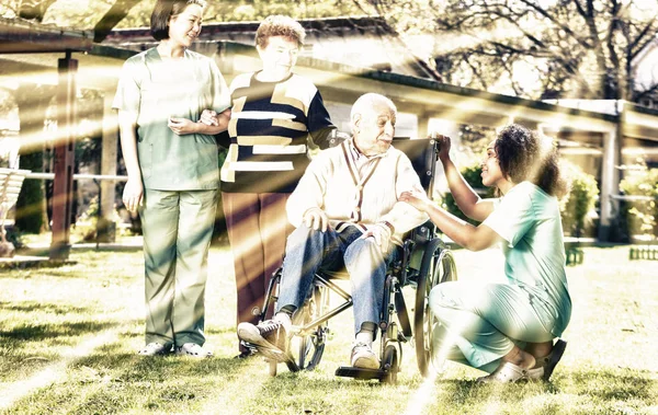 Twee Vrouwelijke Artsen Helpen Ouderen Man Vrouw Met Lichamelijke Handicap — Stockfoto