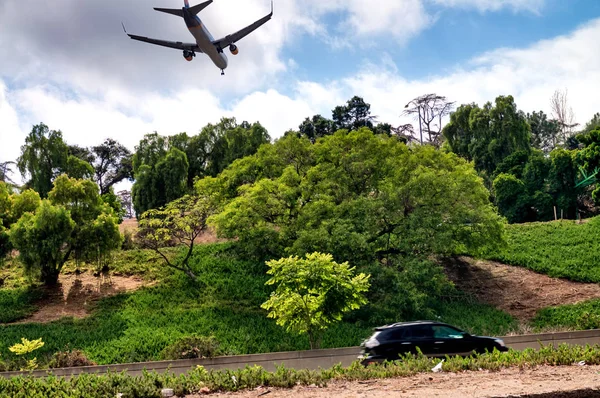 Avión aterrizando cerca de un hermoso parque — Foto de Stock