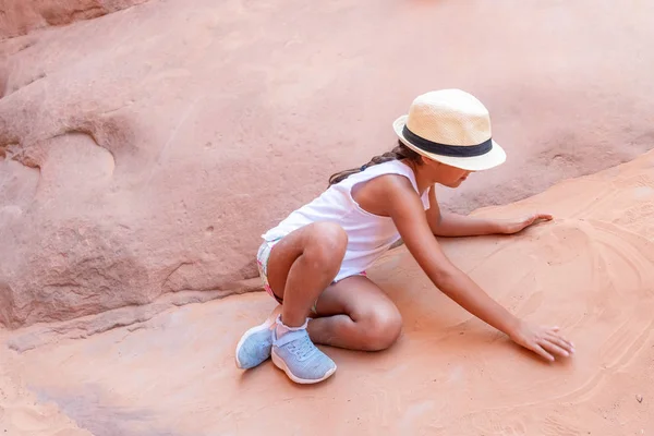 Chica joven con sombrero de paja jugando con arena roja —  Fotos de Stock