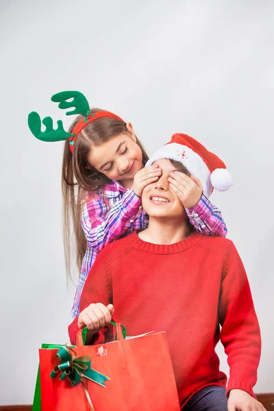 Barn med röd hatt och julklappslådor, isolerade på whit — Stockfoto