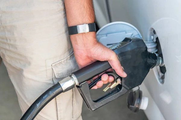 Hombre repostando un coche en una gasolinera, detalle en la mano y pum —  Fotos de Stock