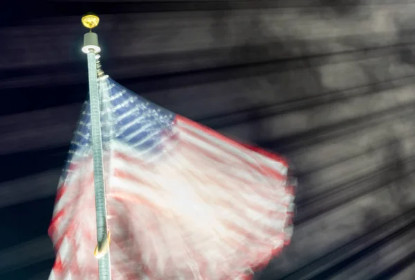 Long exposure of american flag waving at night — Stock Photo, Image