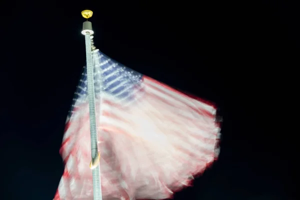 Dlouhá expozice americké vlajce mávající v noci — Stock fotografie
