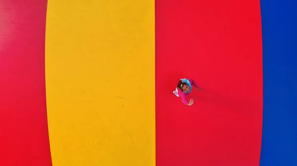 Overhead aerial view of child playing and jumping on playground — Stock Photo, Image