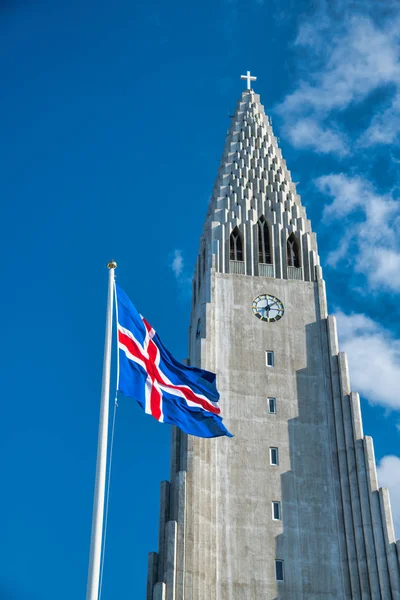 Hallgrimskirkja. Katedrála v Reykjavíku s mávající Islandskou vlajkou — Stock fotografie