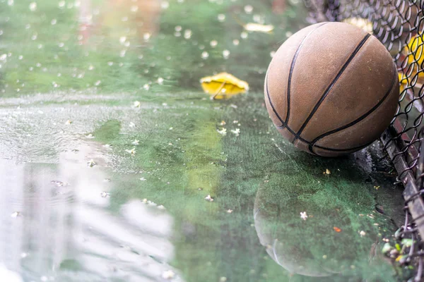 Εγκαταλελειμμένο μπάσκετ σε ένα υπαίθριο χωράφι με βροχή και λιμνούλες — Φωτογραφία Αρχείου