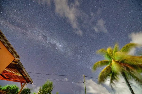 La majestuosa Vía Láctea con casa y palma en primer plano — Foto de Stock