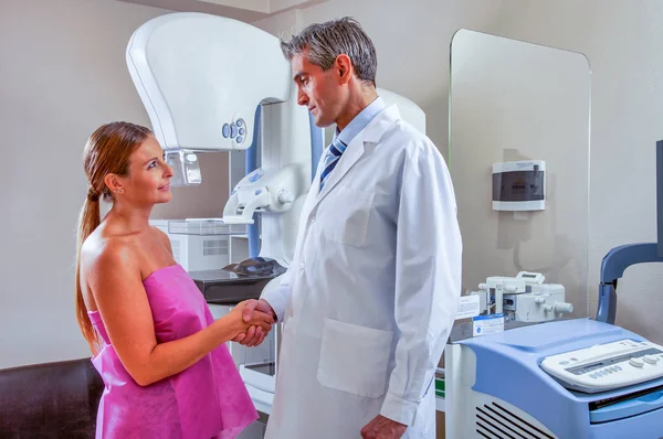 Male doctor shaking hand with female patient in hospital — Stock Photo, Image