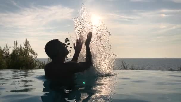 美しい夕日にプールに水を汲み上げるハンサムな大人の男の映像 — ストック動画
