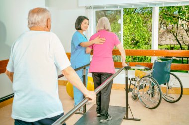Spor salonundaki yaşlılar aletlerle egzersiz yapıyorlar..