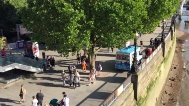 footage of crowd of people walking by Thames Walkway