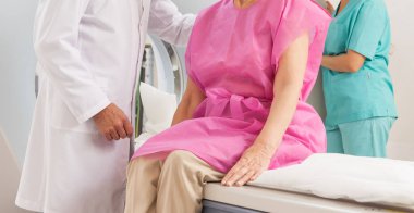 Doktor ve asistan hastayı MRI makinesine sokmaya hazır.