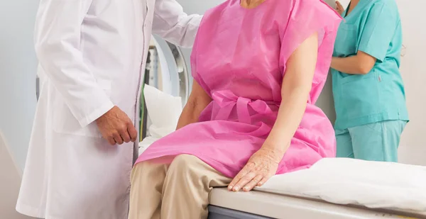 Médico e assistente prontos para colocar o paciente sob máquina de ressonância magnética — Fotografia de Stock