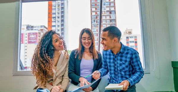 Drie gelukkige multi-etnische jonge collega 's in het kantoor. Ondernemingen — Stockfoto