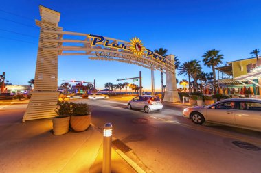 PANAMA CITY, FL - Şubat 2016: Panama City Sahil İskelesi giriş tabelası Gün batımında araba trafiği