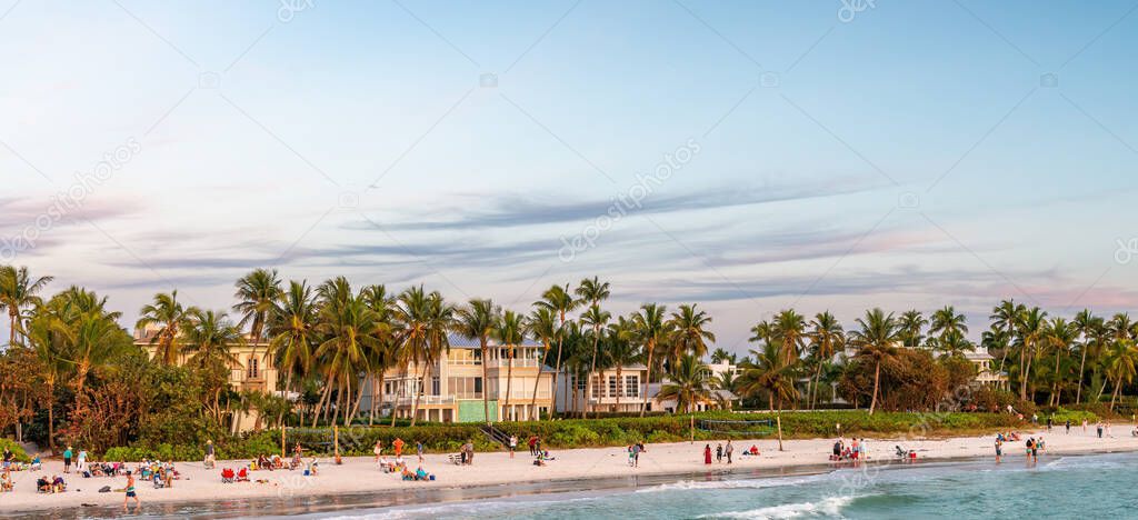 Naples white sand beach and turquoise water at dusk, Florida.