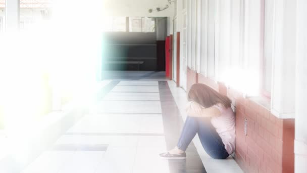 Грустная азиатка, сидящая в школьном коридоре, концепция запугивания, световые лучи, исходящие из внутреннего двора — стоковое видео