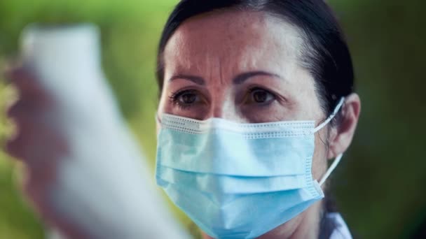 Médecin féminin portant un masque examinant la médecine — Video