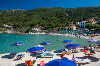 Elba Adası, İtalya - 17 Haziran 2020: Turistler güneşli bir günde Sant Andrea Plajı 'nın tadını çıkarıyorlar..